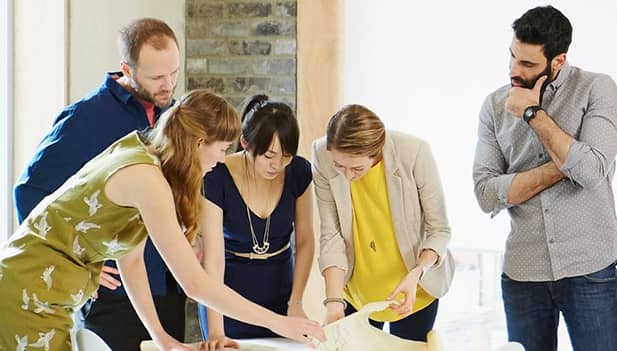 Group of workers looking at papers on a desk