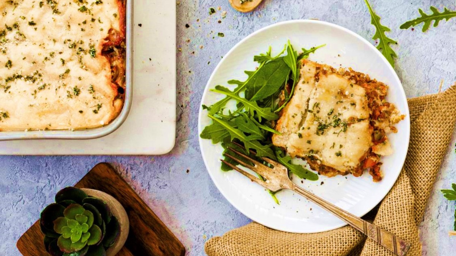 Vegan lentil lasagna on green and white background
